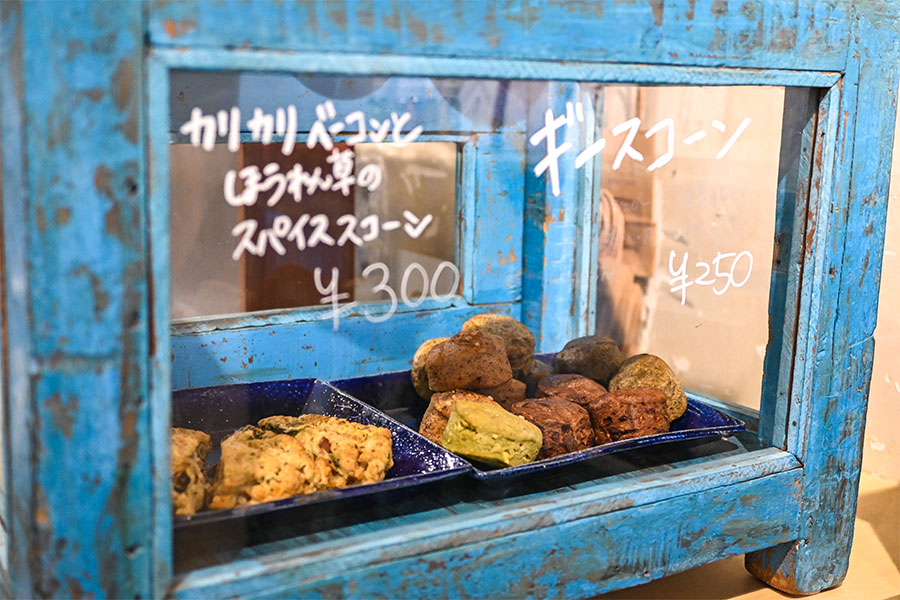 パティシエが毎朝焼き上げるスコーン。バターの代わりにインドのギーを使った「ギースコーン」（250円）やスパイスがほんのり香る「カリカリベーコンとほうれん草のスパイススコーン」（300円）など、新作も随時登場。カフェ利用やテイクアウトもOK。 ※ギー：インドで古くから作られてきたバターオイルの一種